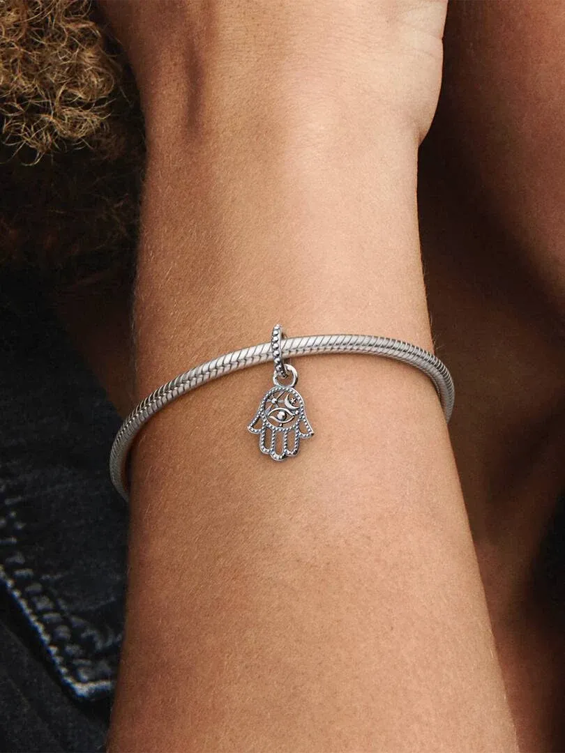 Nahaufnahme des Hamsa-Hand-Charms an einem Silberarmband, getragen am Handgelenk.