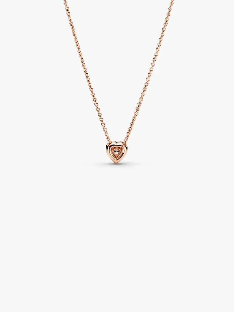 Collar con colgante de corazón visto de frente, cadena fina y fondo blanco puro.