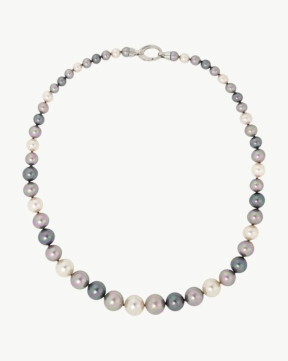 Collier de perles multicolores disposé en cercle sur fond blanc, vue de dessus avec fermoir en argent visible.