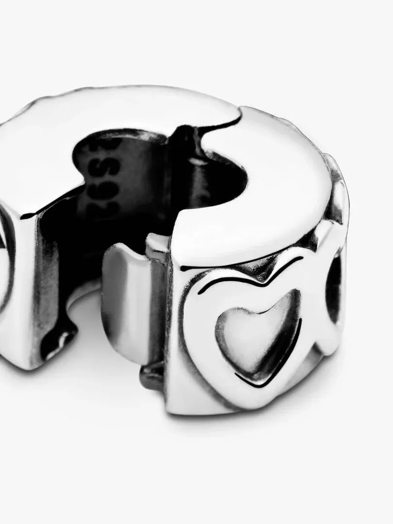 Close-up profiel van de clip charm met hartreliëf, witte achtergrond, vogelvluchtperspectief.