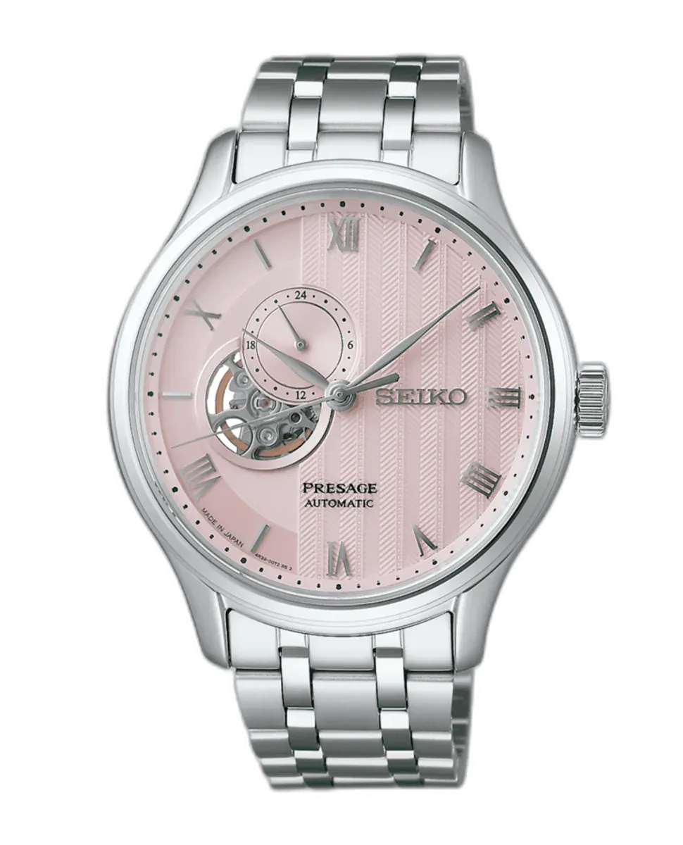 Vista frontal del reloj sobre fondo blanco, destacando la esfera rosa texturizada y el brazalete de acero inoxidable.