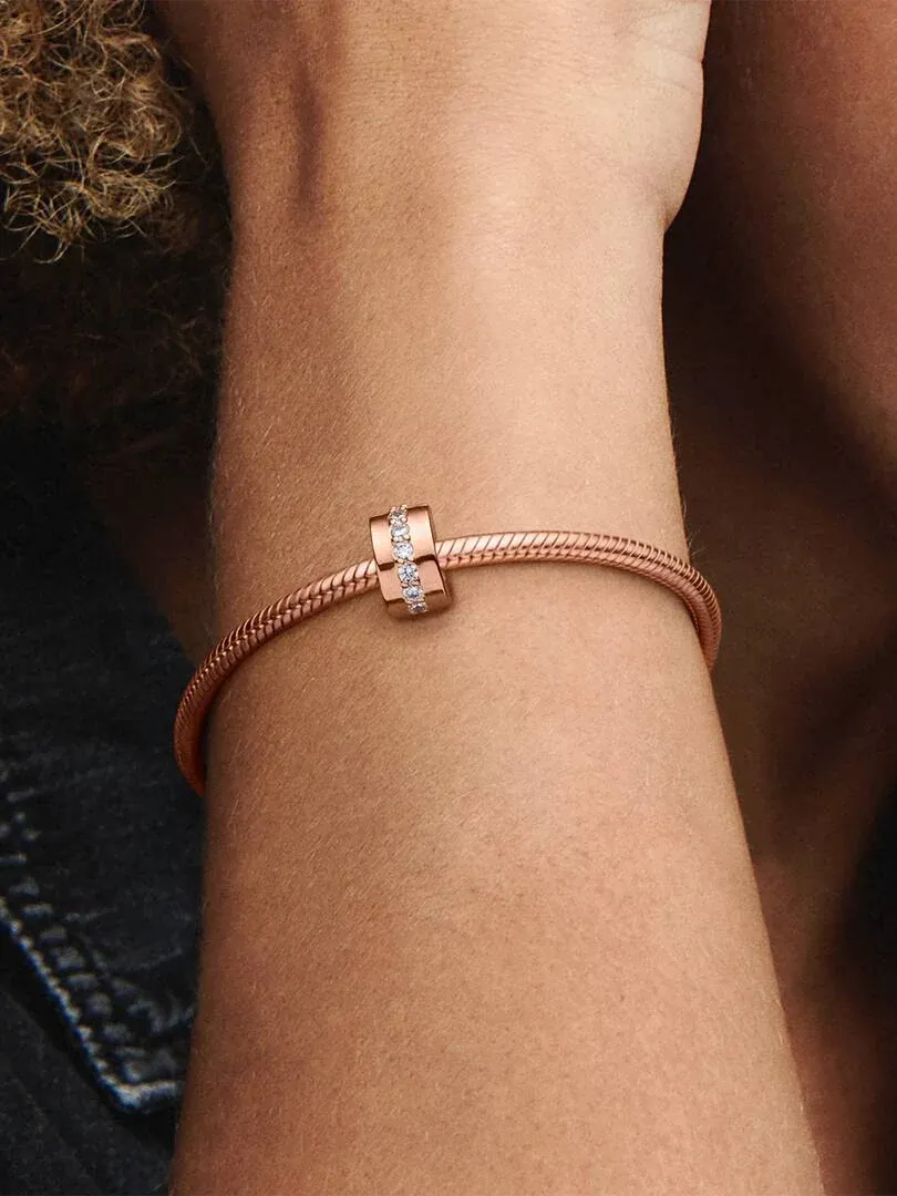 Close-up of the bracelet with spacer charm on a wrist, side view against a blurred background.