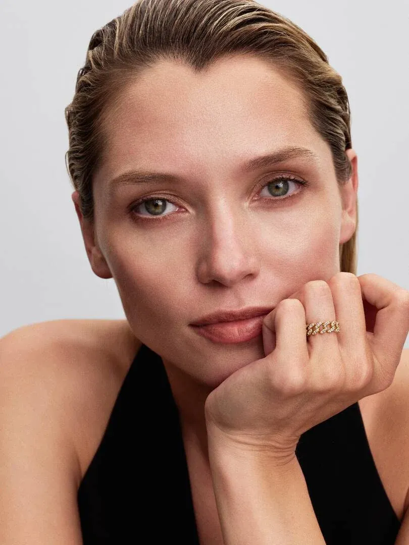 Nahaufnahme eines Models mit dem Cuban-Ring am Finger, Frontansicht mit der Hand unter dem Kinn.