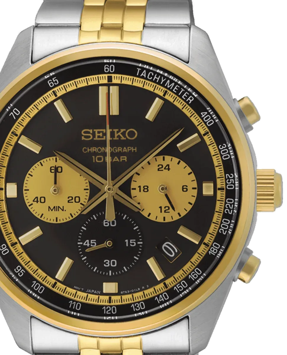 Primer plano frontal de la esfera negra y el bisel dorado del reloj, fondo blanco.