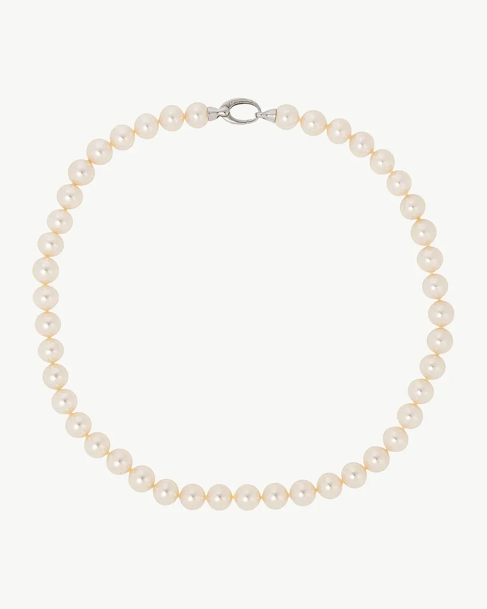 Collar de perlas blancas dispuesto en círculo sobre fondo blanco, vista frontal completa.