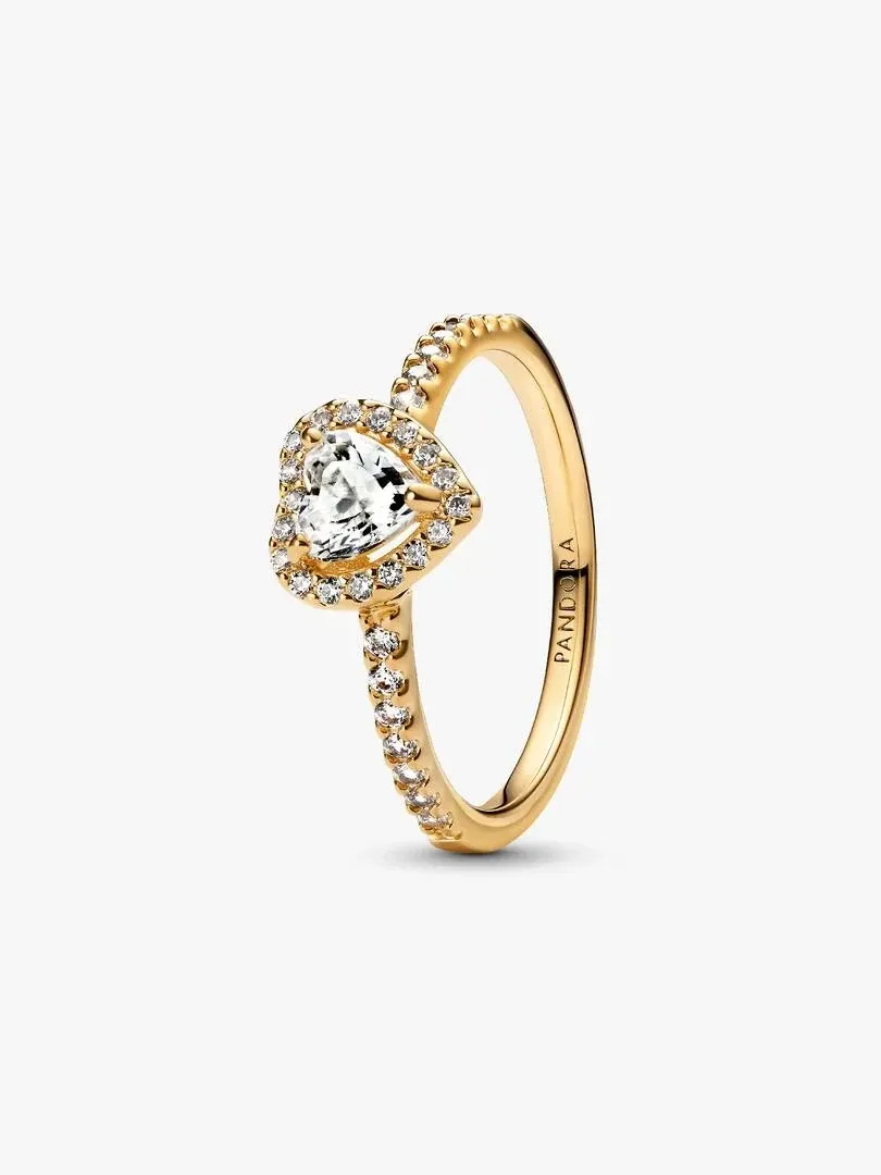 Heart-shaped cubic zirconia ring shown at a side angle, white background, detail of setting and gold band.