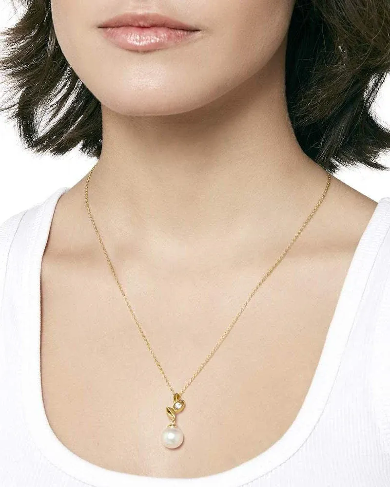 Primer plano del collar con perla sobre el cuello de una modelo, toma frontal con fondo neutro.