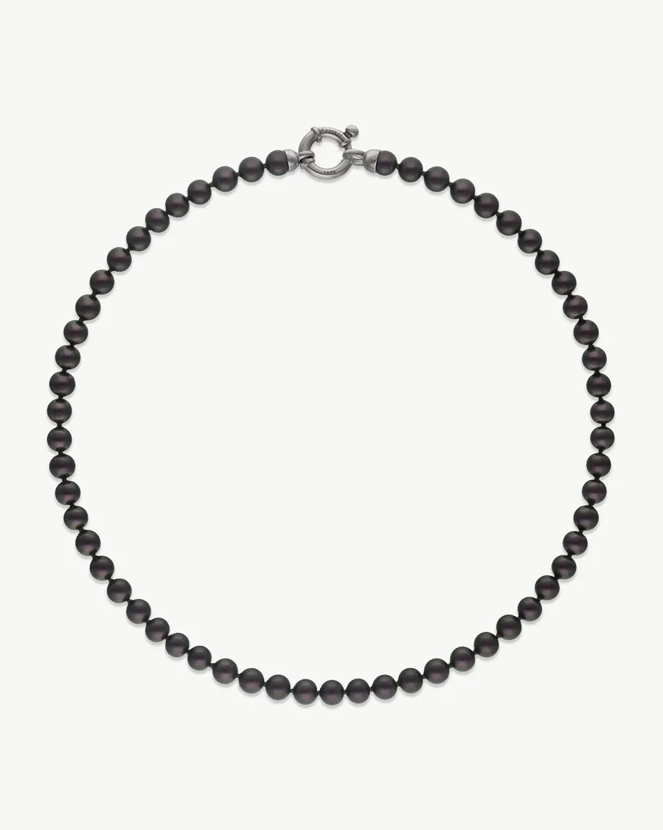 Pearl necklace arranged in a circle on a white background, front view with silver clasp visible.