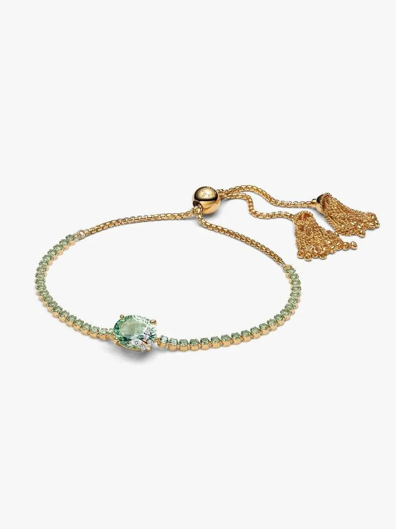 Tennis bracelet with green stones and sliding closure, top view on white background.