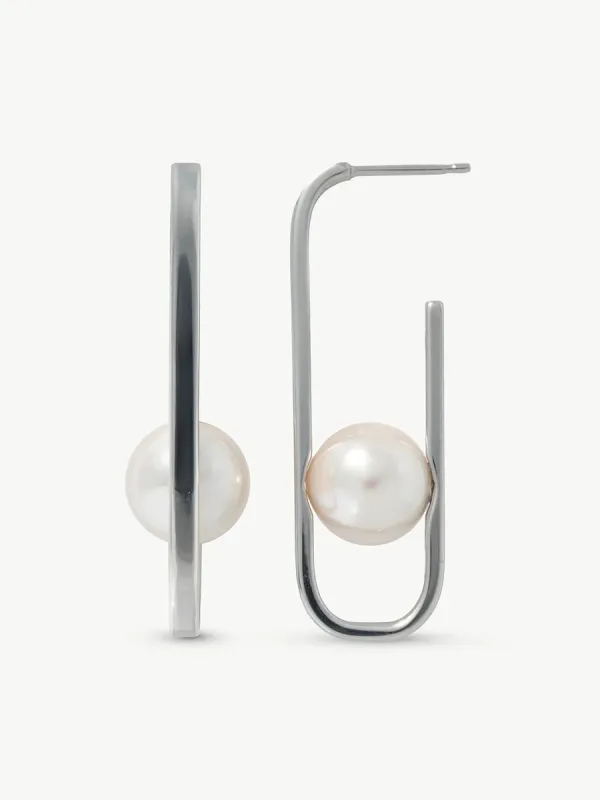 Vista frontal y de perfil de pendientes de perla blanca con estructura ovalada de plata sobre fondo blanco.