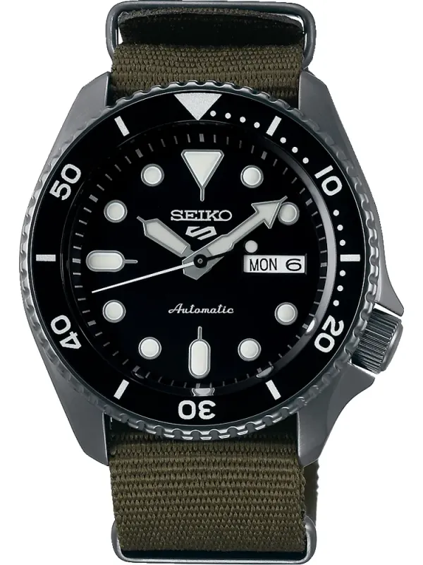 Vista frontal completa del reloj con correa de tela verde oliva y esfera negra, fondo blanco.
