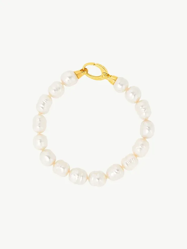 Vista cenital de pulsera dispuesta en círculo sobre fondo blanco, detalle del cierre dorado superior.