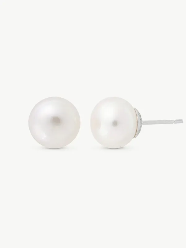 Par de pendientes de perla blanca, vista frontal y lateral con el pincho visible, sobre fondo blanco.