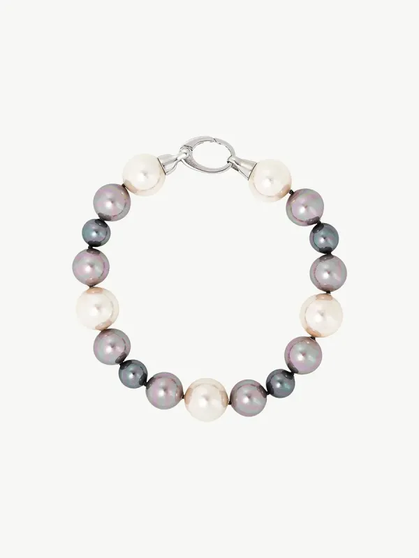 Vista cenital de pulsera de perlas multicolor dispuesta en círculo sobre fondo blanco.