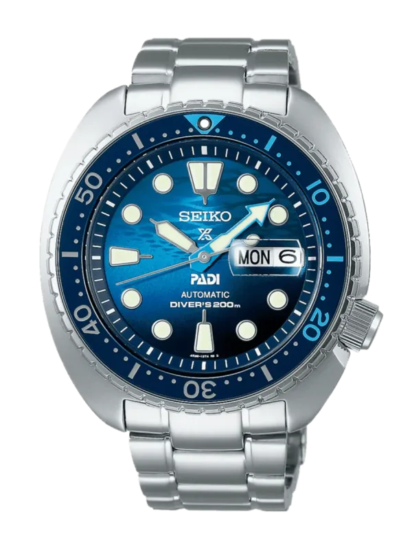 Vista frontal del reloj, esfera azul con bisel rotatorio y brazalete de acero, fondo blanco.