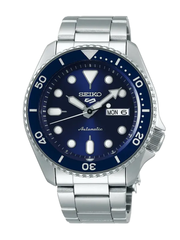 Vista frontal del reloj con esfera azul y brazalete de acero sobre fondo blanco.