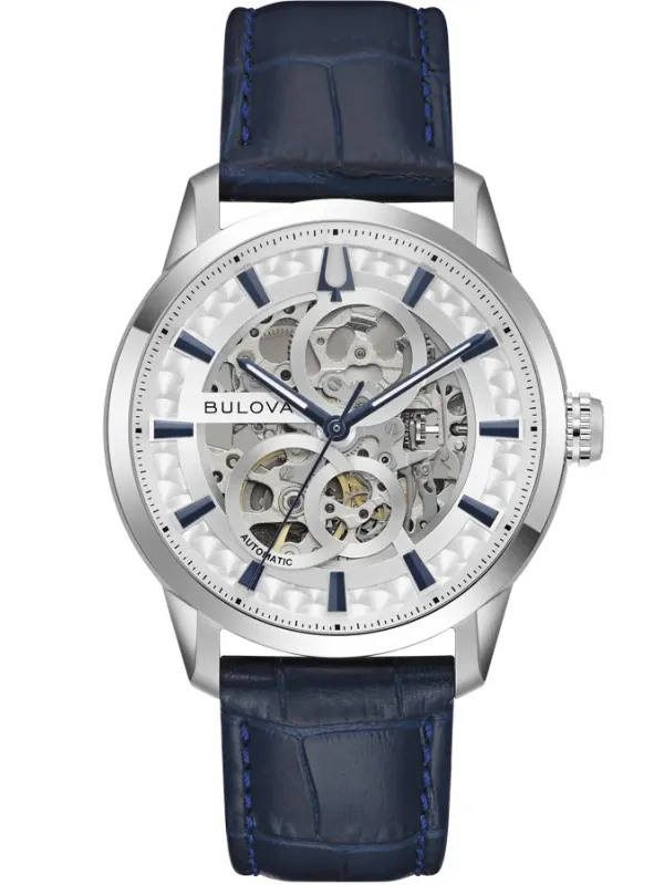 Reloj de pulsera visto de frente sobre fondo blanco, esfera skeleton y correa de piel azul.