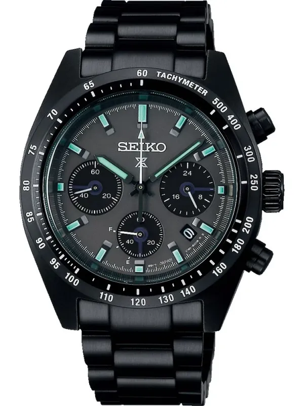 Vista frontal del reloj con esfera negra y bisel taquimétrico, centrado sobre fondo blanco.