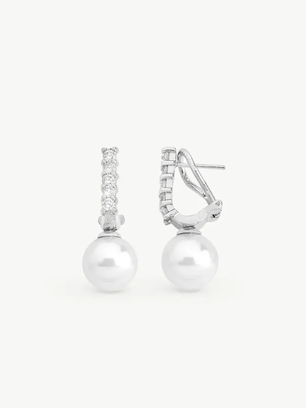 Vista frontal de pareja de pendientes con perlas blancas y engastes de circonitas sobre fondo blanco.