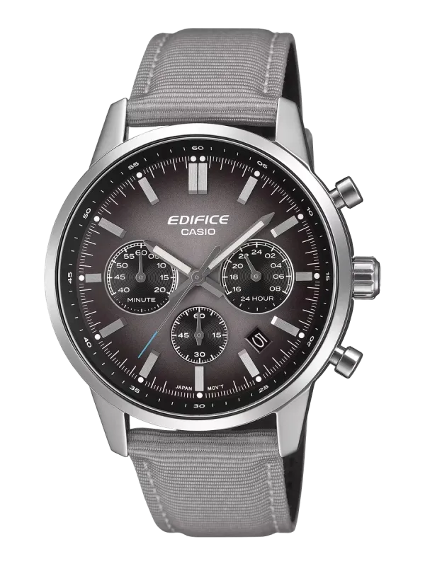 Vista frontal del reloj con correa de tela gris y esfera degradada, sobre fondo dividido en negro y blanco.
