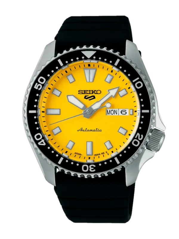 Vista frontal completa del reloj con esfera amarilla y correa negra sobre fondo blanco.