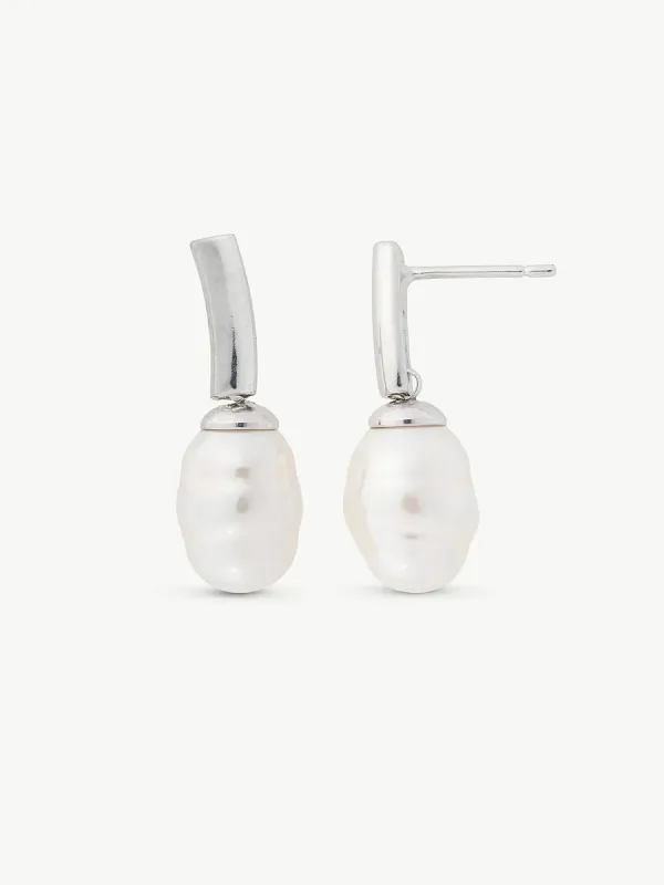 Pareja de pendientes de perla barroca con cierre de espiga en plata, vista frontal sobre fondo blanco.