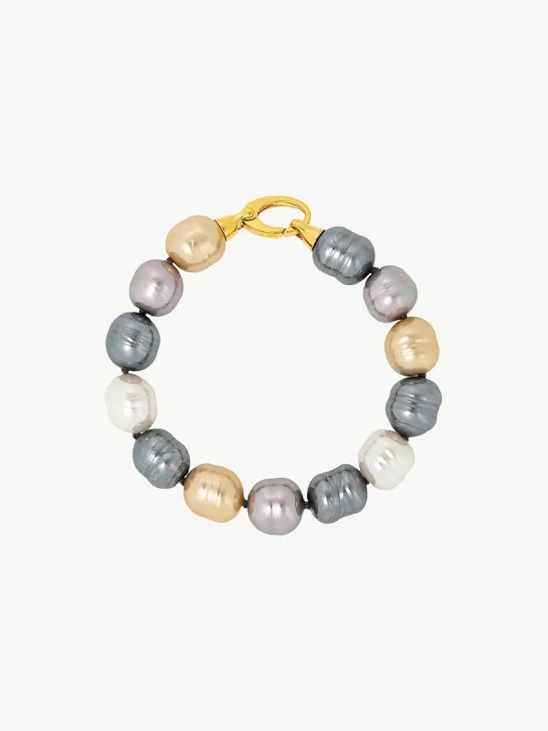 Pulsera de perlas barrocas multicolor dispuesta en círculo sobre fondo blanco, vista cenital con cierre visible.