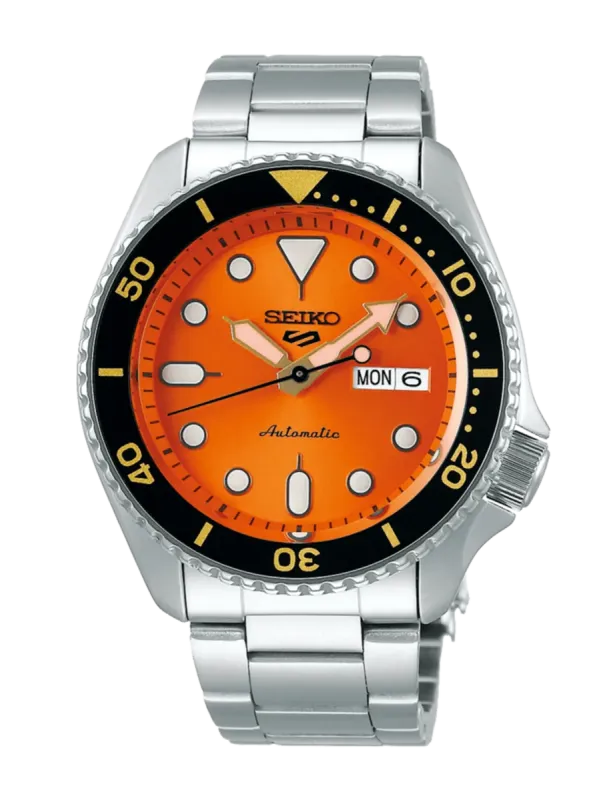 Vista frontal centrada del reloj con esfera naranja y brazalete de acero, sobre fondo blanco.