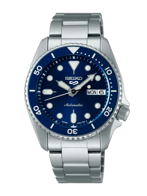 Vista frontal del reloj con esfera azul y brazalete de acero, centrado sobre fondo blanco.