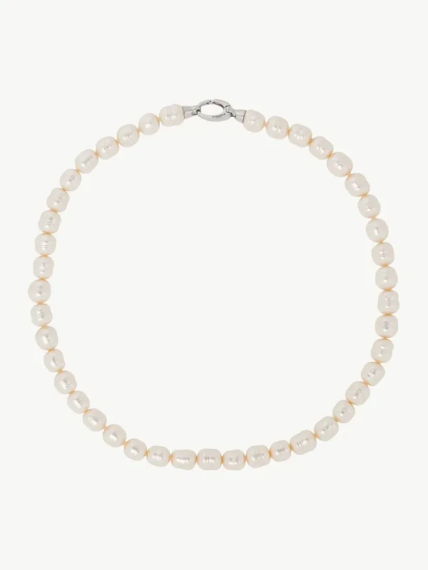 Collar de perlas barrocas blancas dispuesto en círculo sobre fondo blanco, vista cenital con cierre visible.