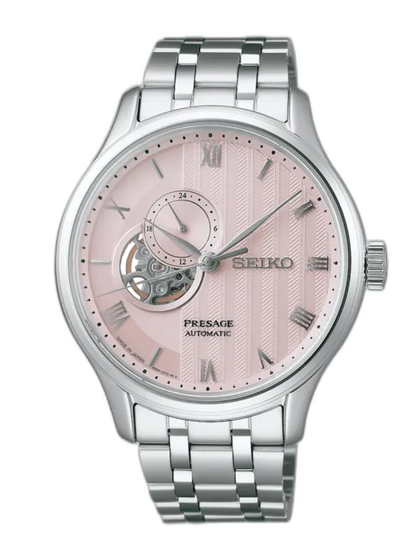 Vista frontal del reloj sobre fondo blanco, destacando la esfera rosa texturizada y el brazalete de acero inoxidable.