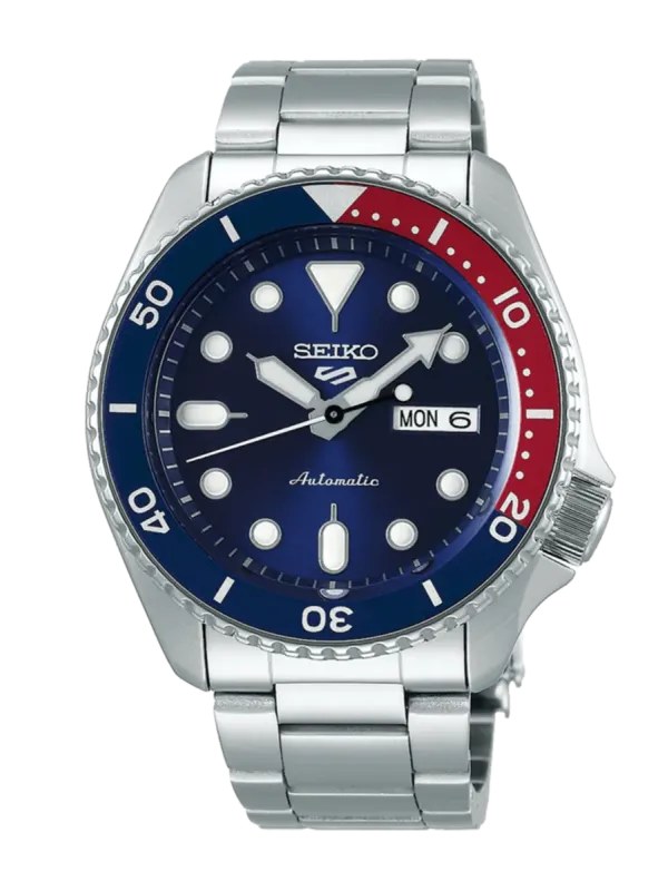 Vista frontal de reloj con bisel bicolor azul y rojo, esfera azul y brazalete de acero sobre fondo blanco.