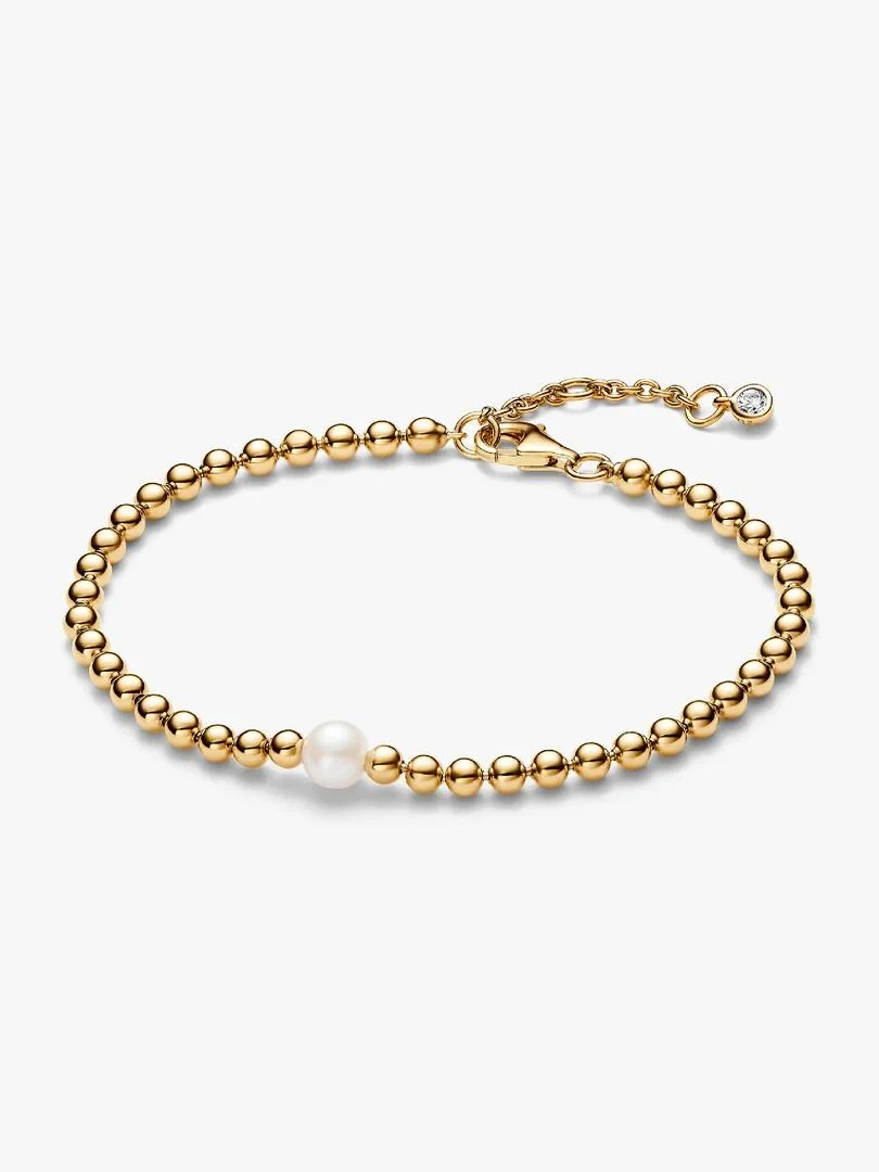 Gouden kralenarmband met centrale parel, vooraanzicht onder een hoek op witte achtergrond.