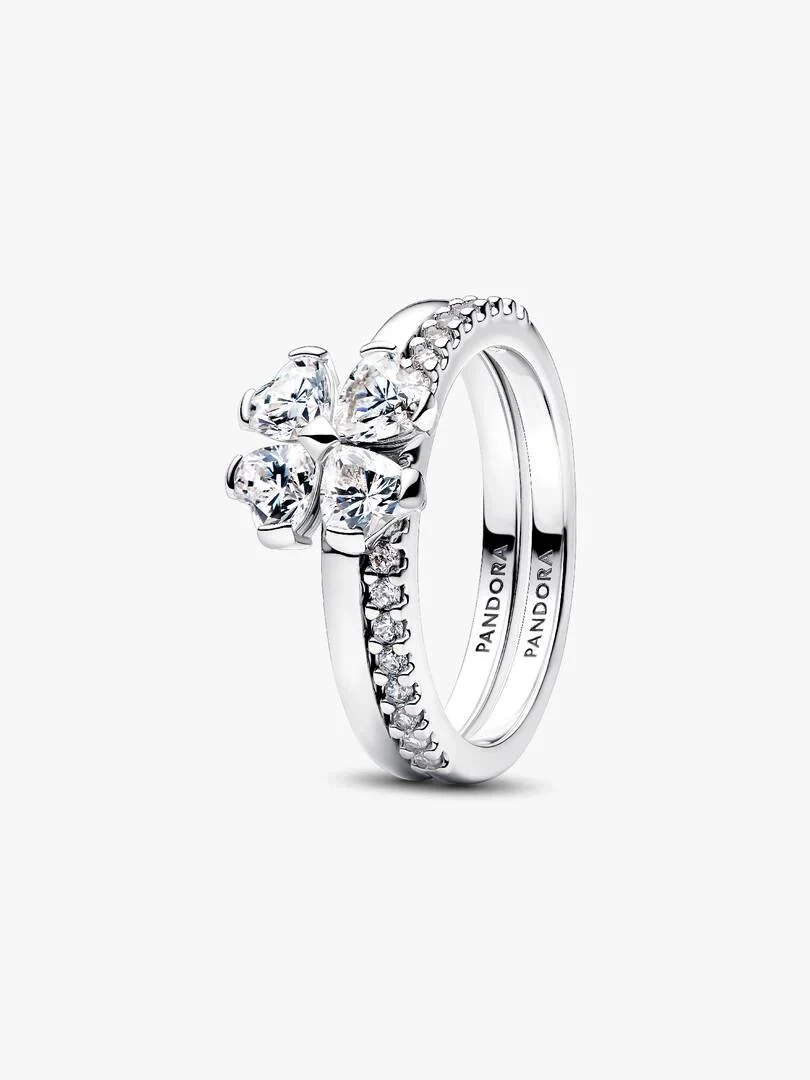 Vue de profil de deux anneaux en argent entrelacés avec des pierres en forme de cœur, fond blanc.