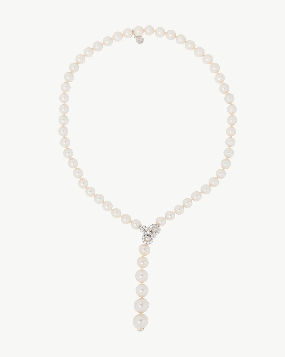 Collier de perles blanches sur fond blanc, vue de face avec un pendentif scintillant.