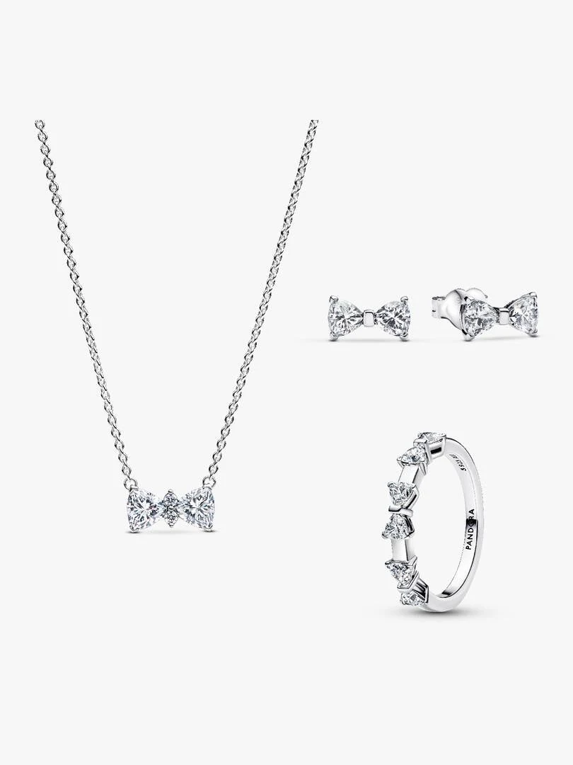 Set aus Halskette, Ohrsteckern und Ring mit Schleifendesign auf weißem Hintergrund, Frontansicht.