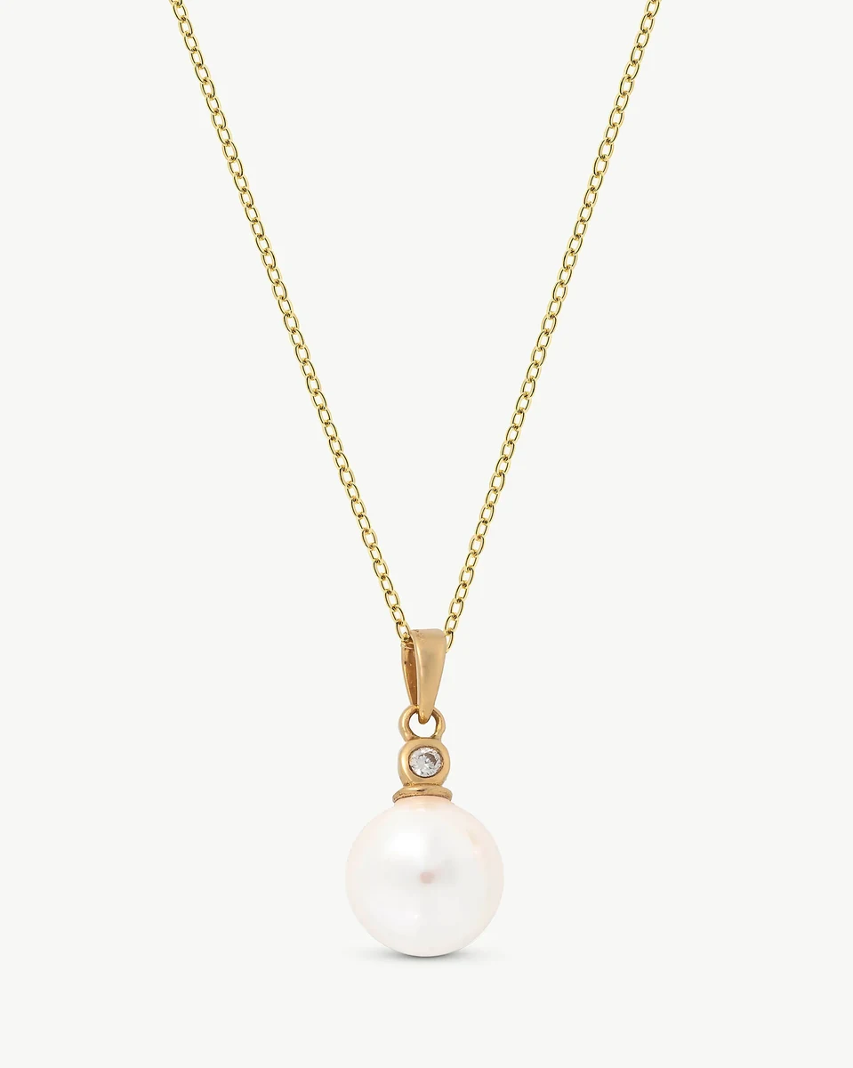 Collar con colgante de perla y diamante, vista frontal sobre fondo blanco puro.