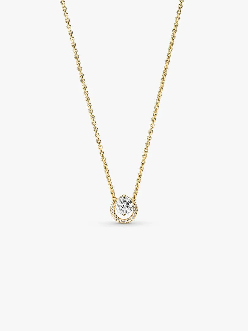 Vue de face du collier avec pendentif circulaire, chaîne dorée fine sur fond blanc neutre.