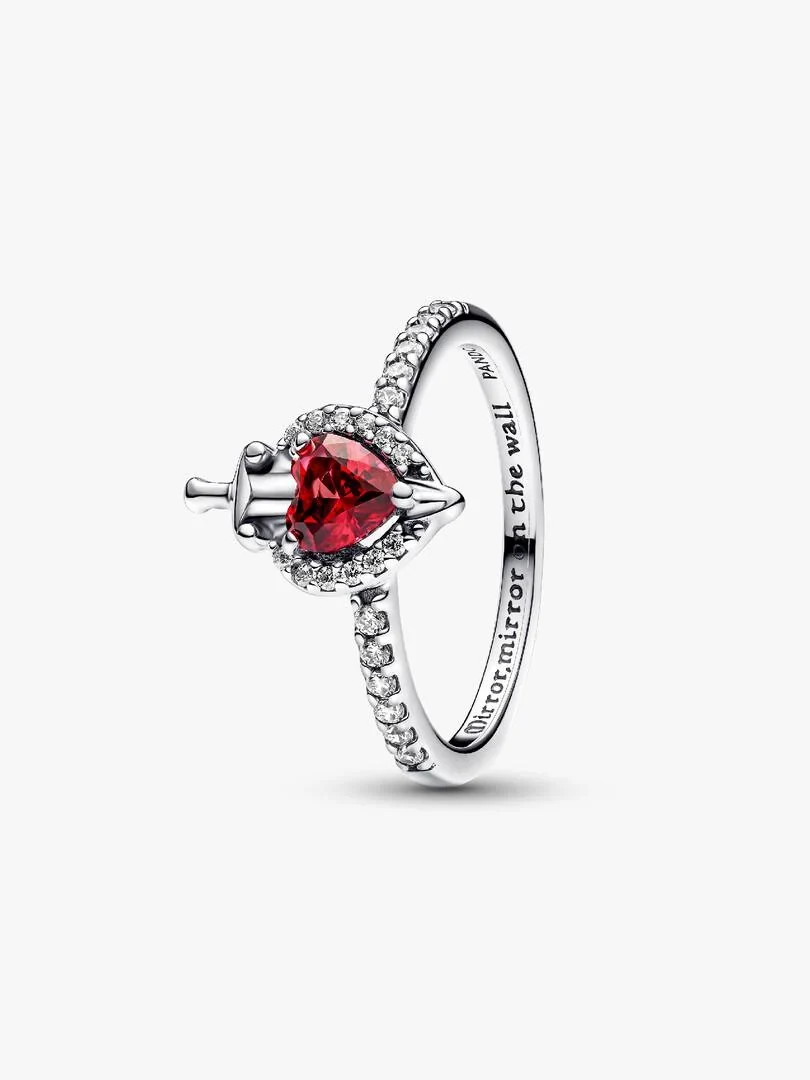 Anillo de plata con corazón rojo y espada, vista lateral en ángulo sobre fondo blanco.