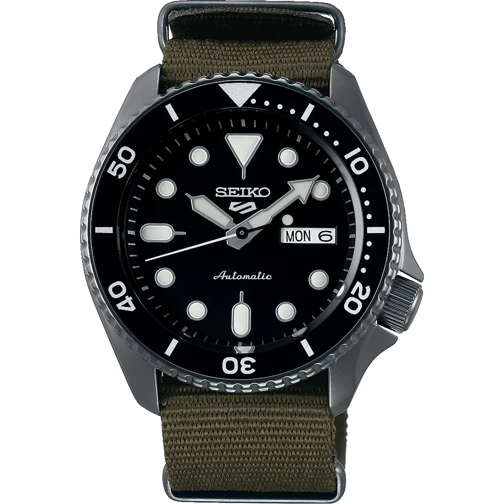Vista frontal completa del reloj con correa de tela verde oliva y esfera negra, fondo blanco.