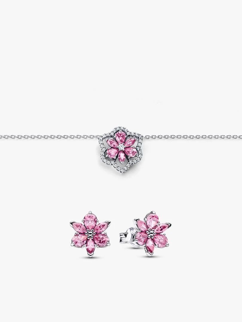 Collar y pendientes de flor rosa sobre fondo blanco, vista frontal con detalle de las circonitas.