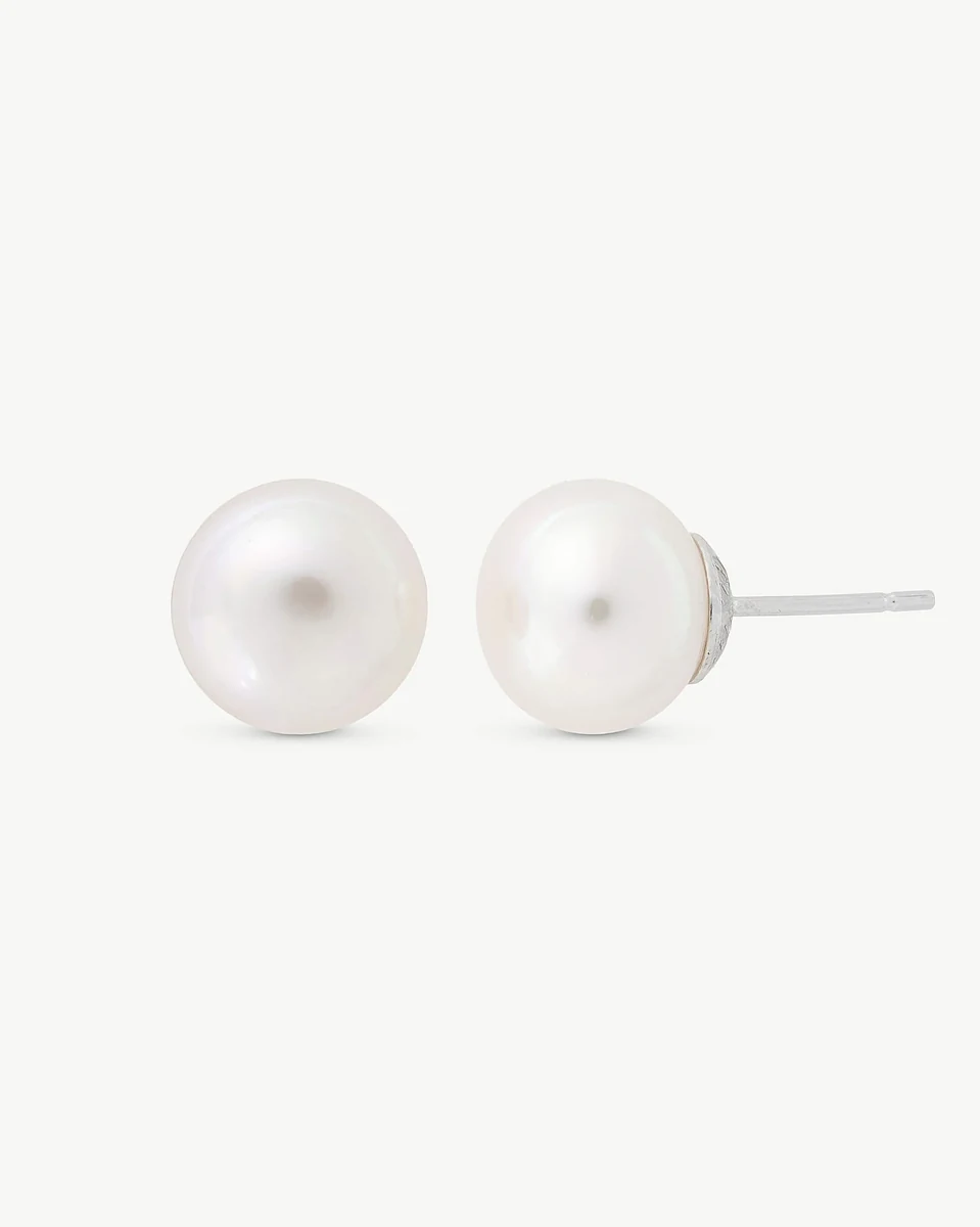 Vue de face des boucles d'oreilles en perles blanches sur fond blanc, montrant le profil de la tige en argent.