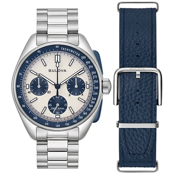 Vista frontal del reloj con brazalete de acero y correa adicional de cuero azul, fondo blanco.