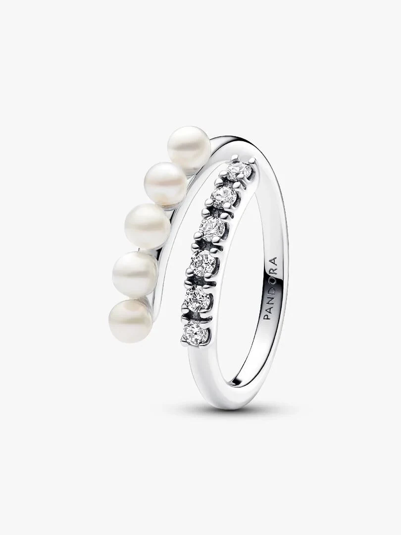 Anillo abierto de plata con perlas y pavé, vista lateral en ángulo sobre fondo blanco.