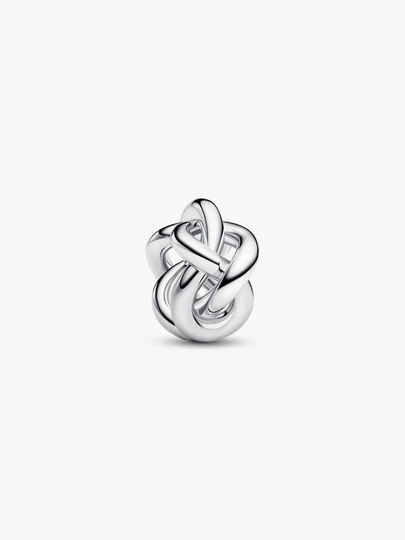 Silver infinity knot charm, front view from a slight high angle on a pure white background.