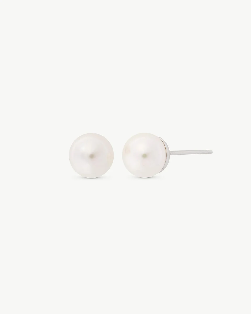 Pearl stud earrings shown in profile view, displaying the silver post on a white background.