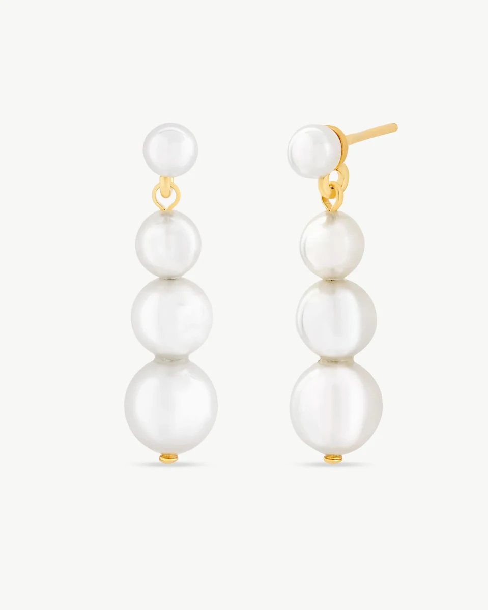 Vista frontal y lateral de los pendientes largos con perlas blancas sobre fondo blanco.