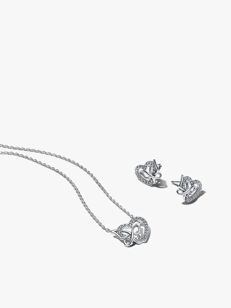 Conjunto de collar y pendientes sobre fondo blanco, toma cenital con disposición diagonal.