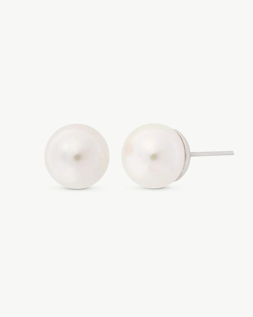 Pair of white pearl earrings on a white background, front view with one earring in profile.