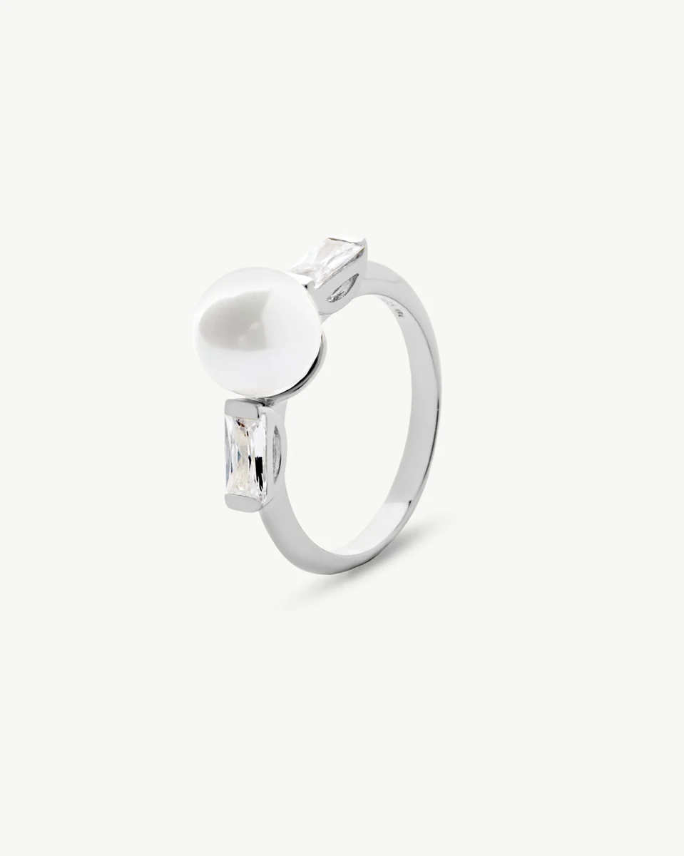 Bague en argent avec perle centrale et zircons, vue de trois quarts sur fond blanc.